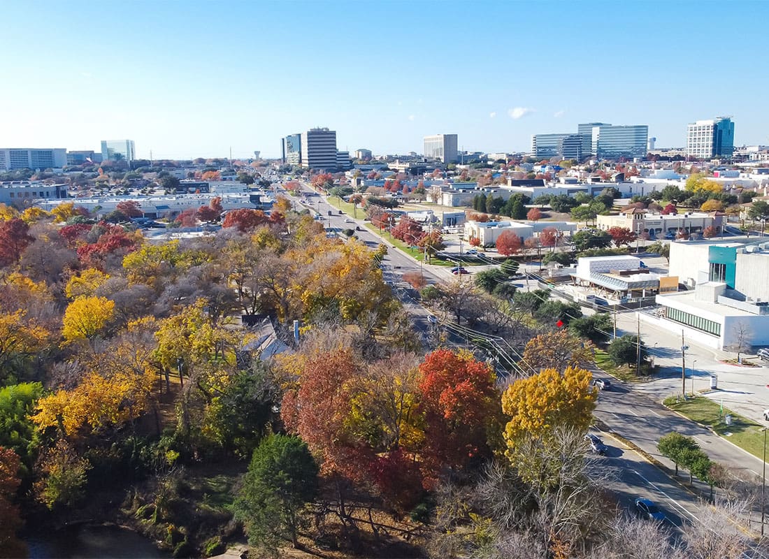 Addison, TX - Yellow Red Orange Fall Foliage Over Urban Park Along Belt Line Road With Office Buildings, Skylines